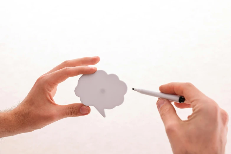 a person drawing on a piece of paper with a marker, a drawing, by Daniel Gelon, unsplash, conceptual art, speech bubbles, paper cut out, miniature product photo, two people