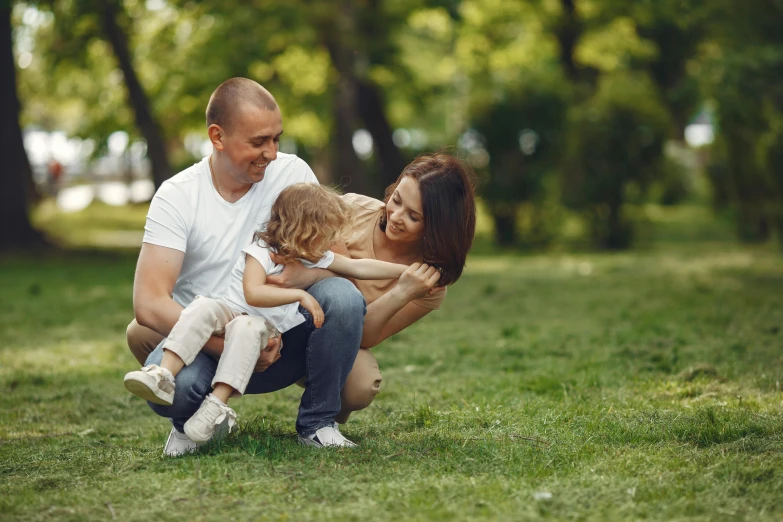 a man and woman playing with a child in a park, pexels contest winner, 15081959 21121991 01012000 4k, hugging her knees, a green, immature