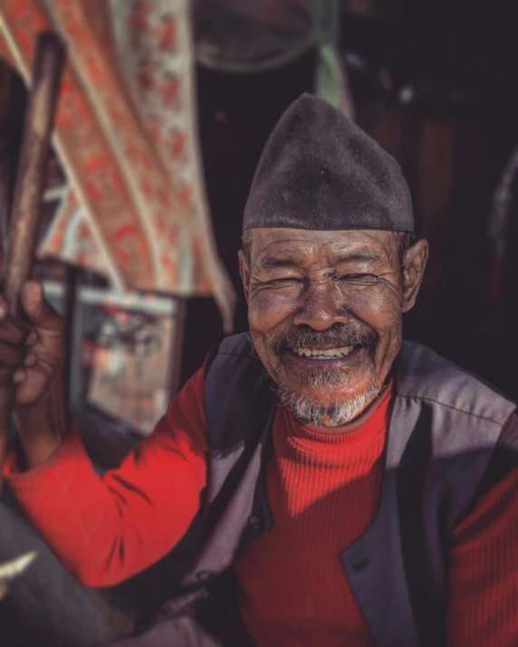 a close up of a person holding a baseball bat, inspired by Steve McCurry, pexels contest winner, sumatraism, smiling man, nepal, old color photograph, (good looking )