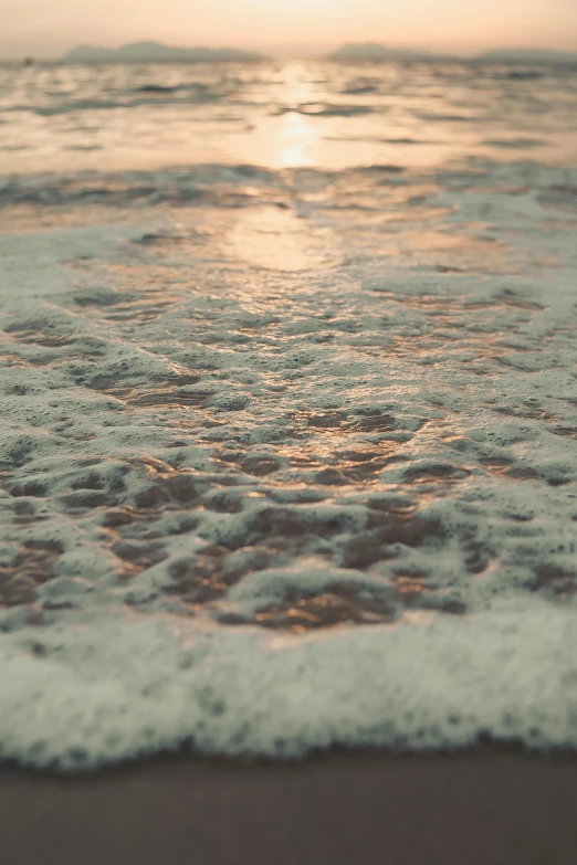 the sun is setting over the water on the beach, inspired by Elsa Bleda, covered in salt, up-close, volumetric water, bubbly