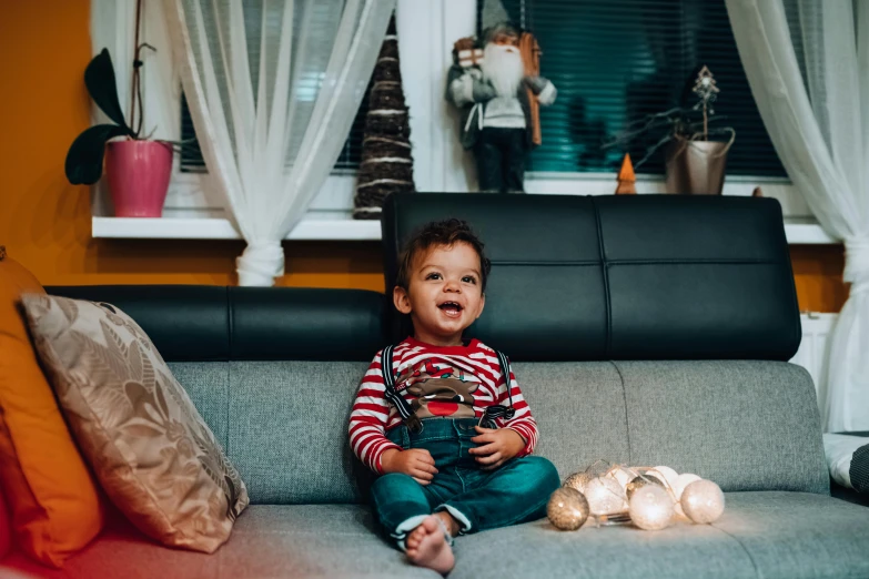 a small child sitting on top of a couch, by Adam Marczyński, pexels contest winner, happening, decorations, avatar image, handsome, holiday vibe