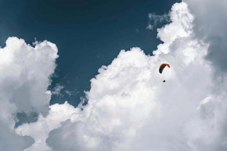 a person that is flying a kite in the sky, by Niko Henrichon, pexels contest winner, minimalism, giant cumulonimbus cloud, d. b. cooper skydiving, cafe in the clouds, parachutes