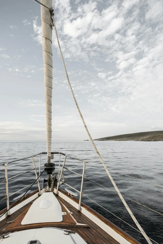 a view from the bow of a sailboat on the water, by Peter Churcher, minimalism, croatian coastline, pale sky, somalia, low ultrawide shot