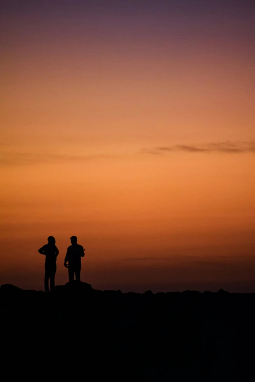 a couple of people standing on top of a hill, by Peter Churcher, ((sunset)), big island, waiting, telephoto shot