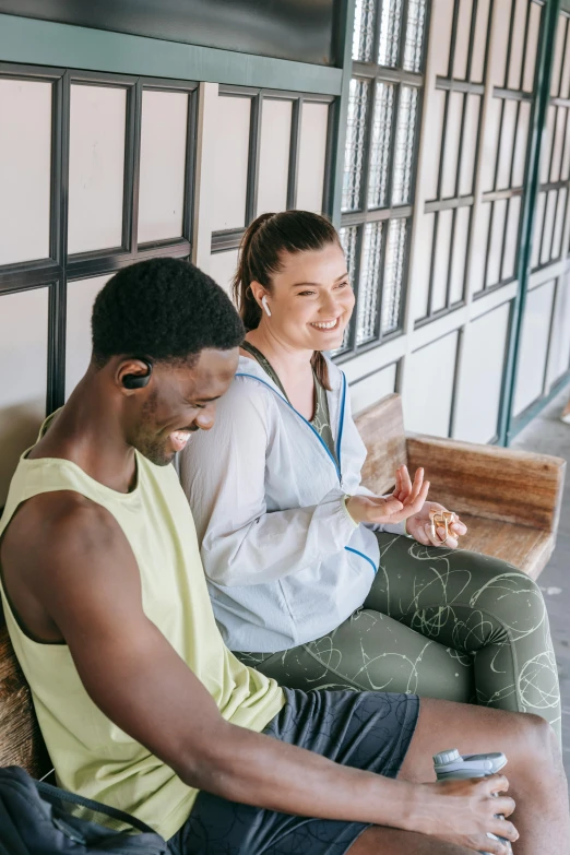 a man and a woman sitting on a bench, earbuds, health supporter, reaching out to each other, lounge