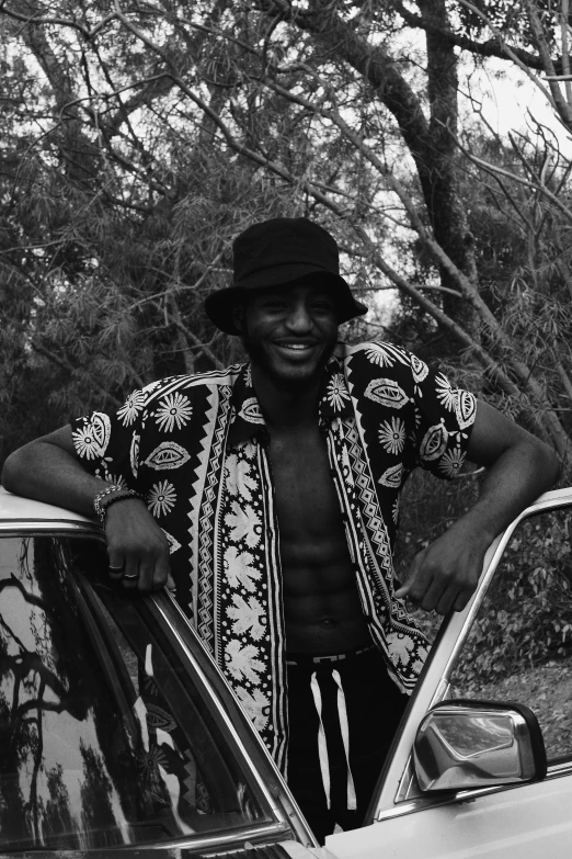 a black and white photo of a man standing next to a car, by Clifford Ellis, playboi carti, smiling seductively, covered in vines, snake man