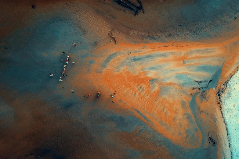 a group of people standing on top of a sandy beach, an ultrafine detailed painting, inspired by Filip Hodas, pexels contest winner, dutch angle from space view, oil slick colors, cyan and orange, made of oil and water