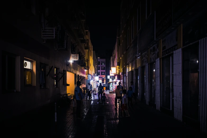 a group of people walking down a street at night, pexels contest winner, jeddah city street, fan favorite, neon and dark, shady alleys