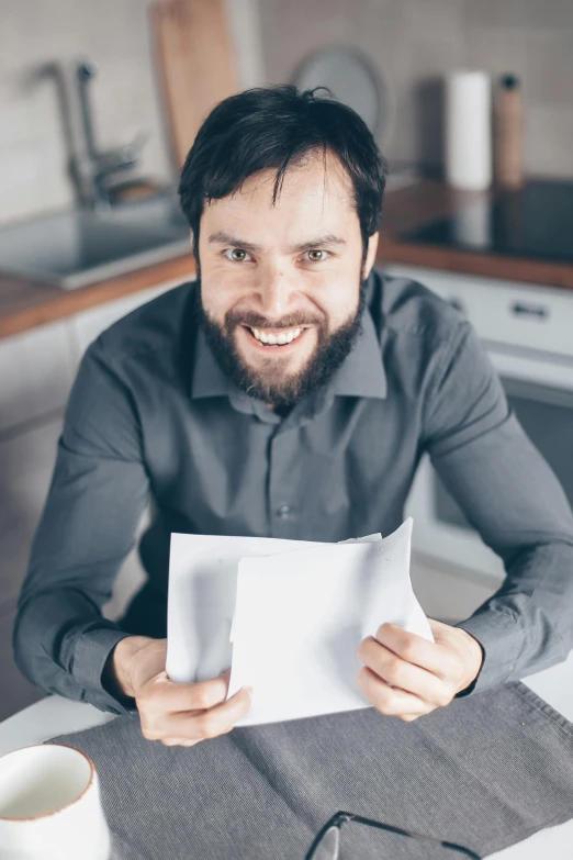 a man sitting at a kitchen table holding a piece of paper, cocky smirk, beard stubble, it specialist, multiple stories