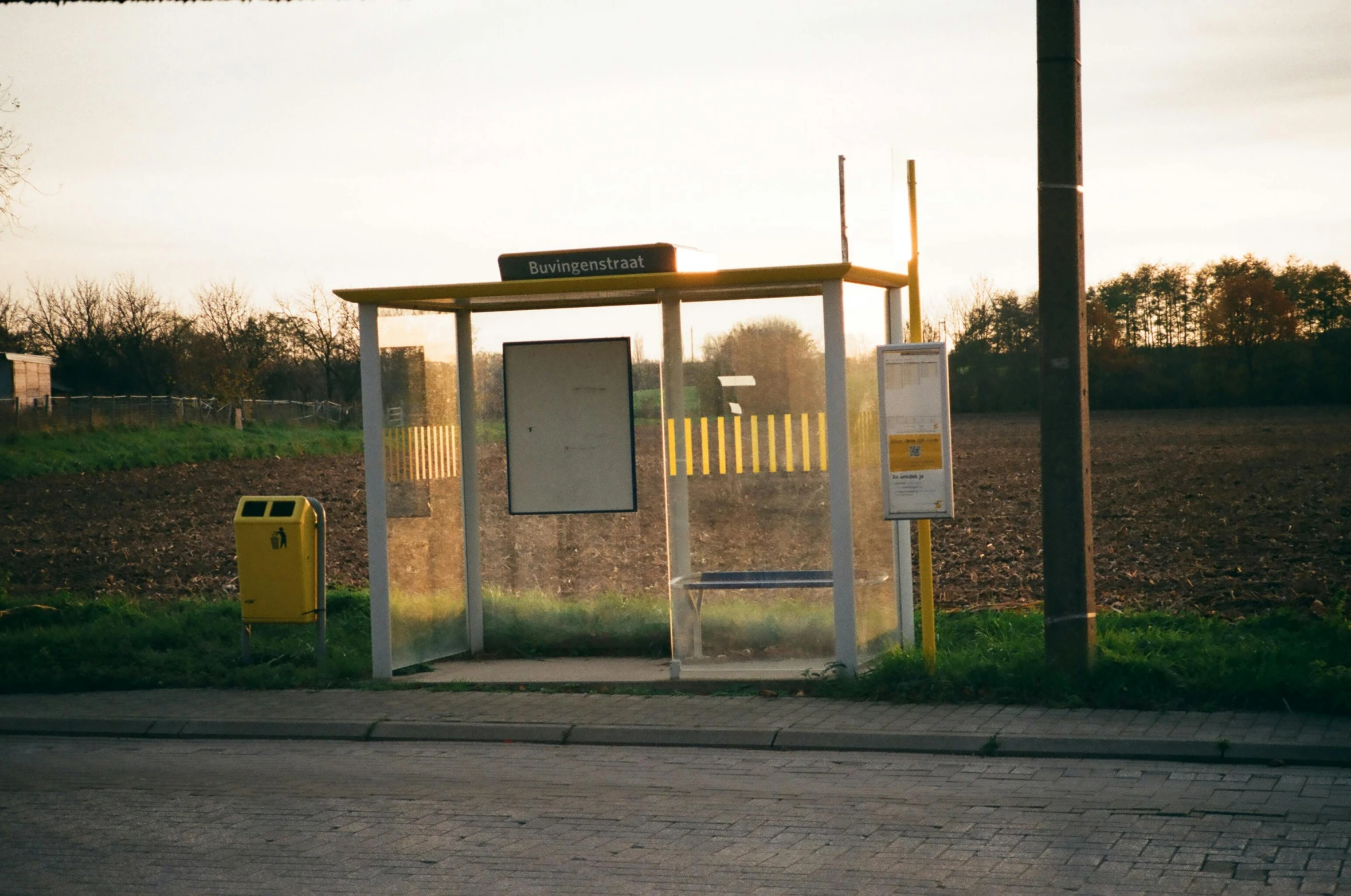 a bus stop sitting on the side of a road, by Jan Tengnagel, goldenhour, early 2 0 0 0 s, bartlomiej gawel, northern france