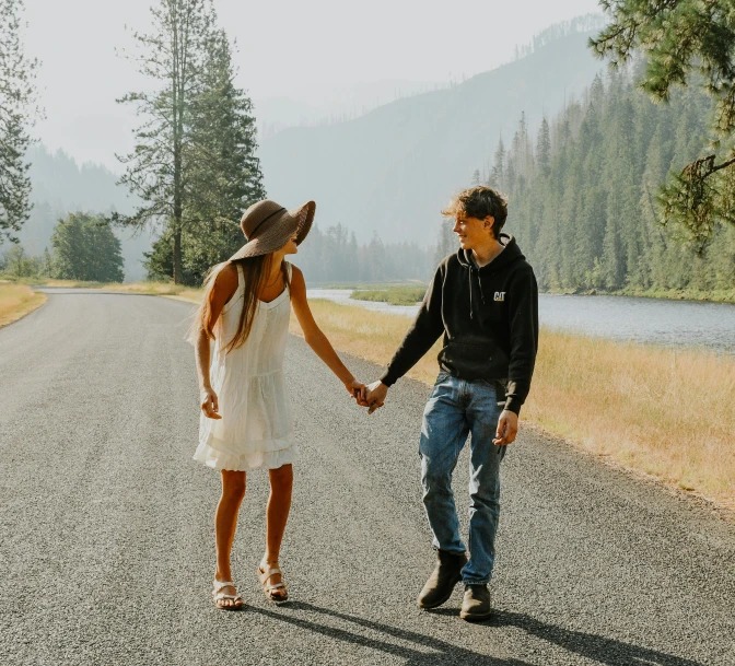 a man and woman walking down a road holding hands, pexels contest winner, yosemite, handsome girl, background image, on a lake