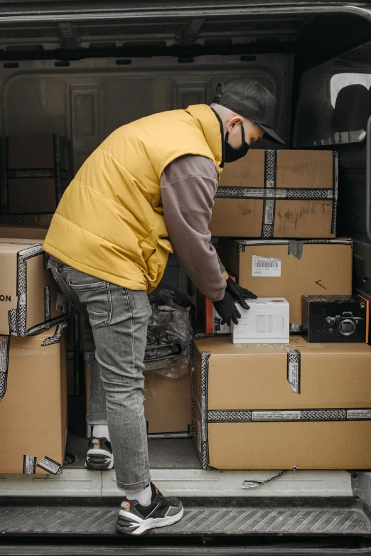 a man loading boxes into the back of a van, pexels contest winner, gold, grey, thumbnail, ecommerce photograph