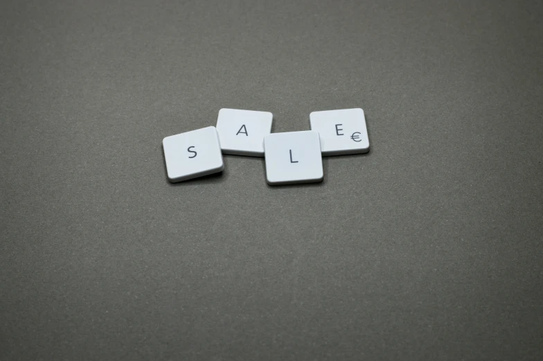 a couple of dice pieces sitting on top of a table, sales, grey, square, letters