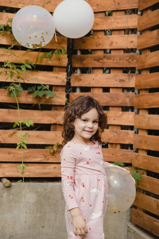 a little girl standing in front of a bunch of balloons, a picture, stood outside a wooden cabin, profile image, portrait image, low iso