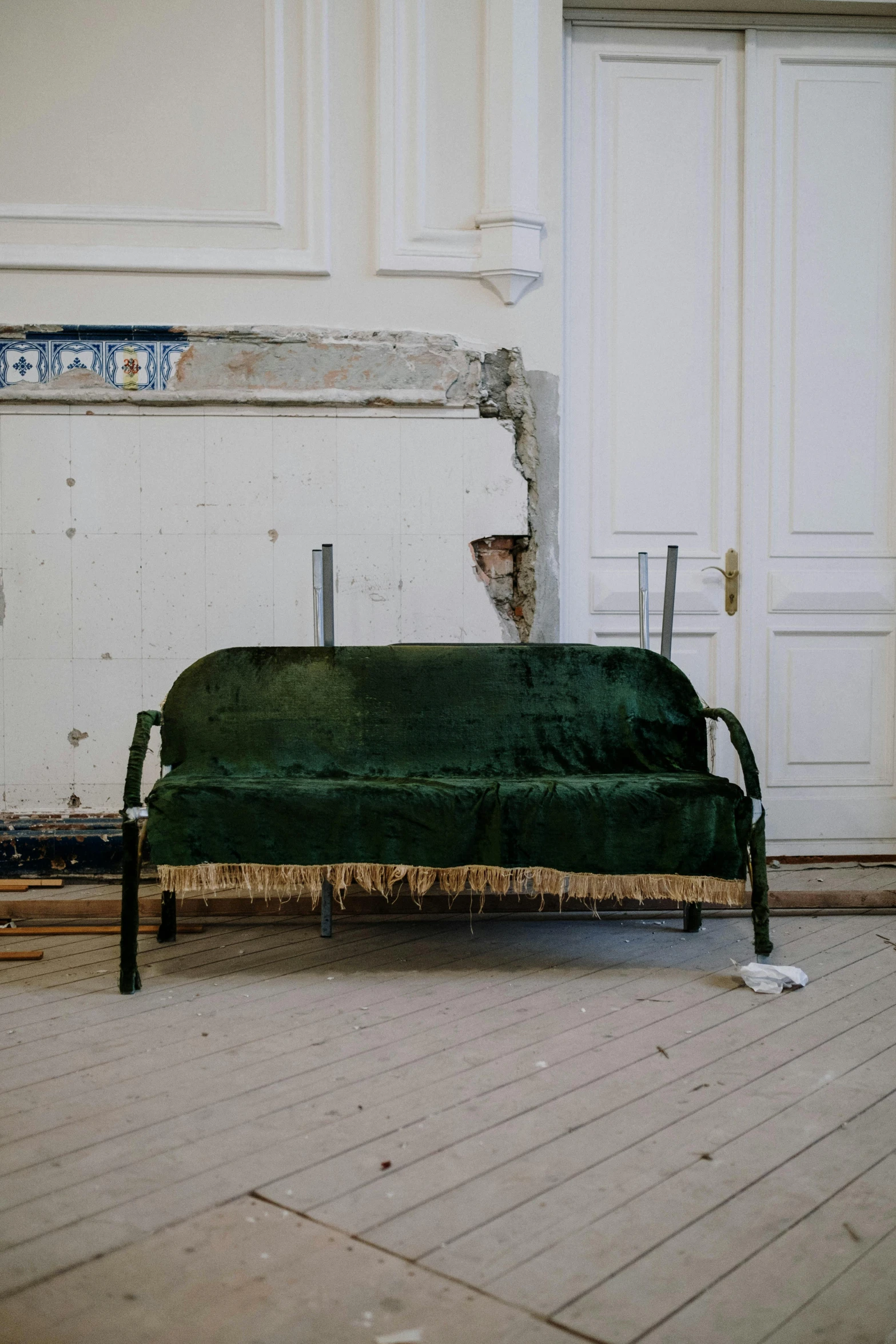 a green couch sitting on top of a hard wood floor, inspired by Paul-Émile Borduas, arte povera, under repairs, biedermeier, 2010s, bench
