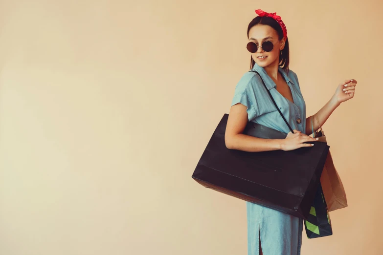 a woman in a blue jumpsuit holding a black bag, pexels contest winner, minimalism, quirky shops, with a bunch of stuff, happy girl, wearing a fancy dress