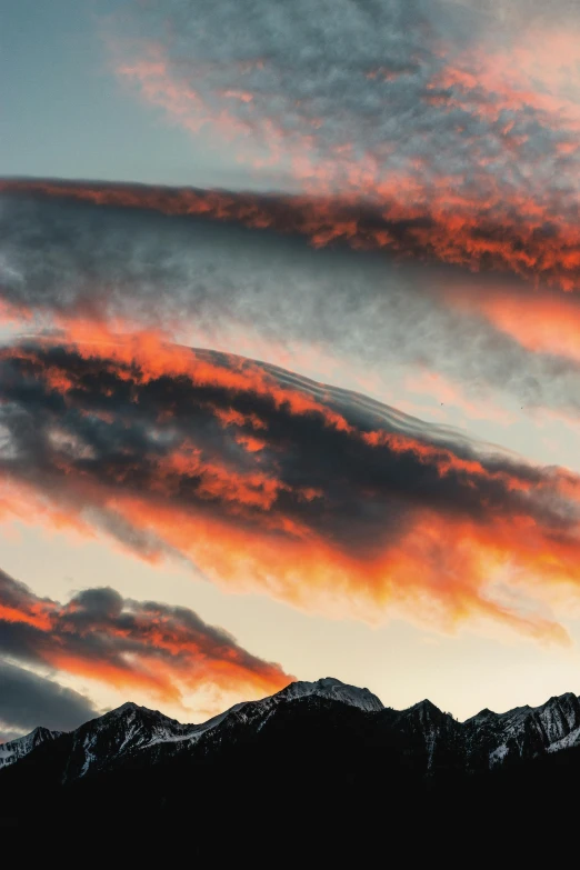 a sky with some clouds and mountains in the background, by Peter Churcher, unsplash contest winner, fire and ice, spiral clouds, red sunset, crisp lines