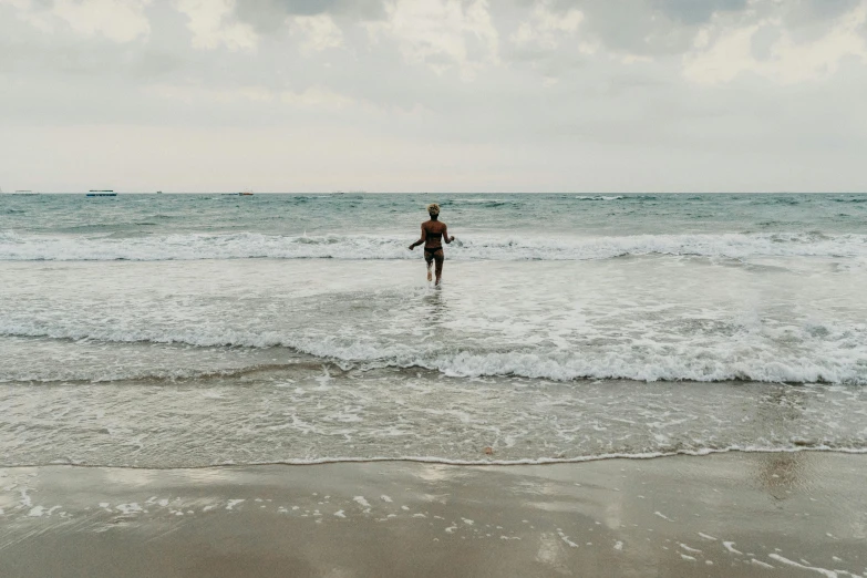 a person standing in the ocean holding a surfboard, by Caro Niederer, unsplash, renaissance, black sea, slight overcast, little kid, swimming