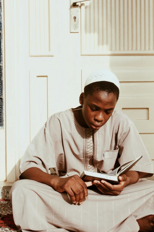 a man sitting on the floor reading a book, hurufiyya, imane anys, neco arc, religious, ( ( theatrical ) )