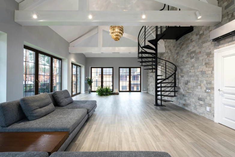 a living room filled with furniture and a spiral staircase, pexels contest winner, light and space, hardwood floor, flat grey color, stone floor, professional comercial vibe