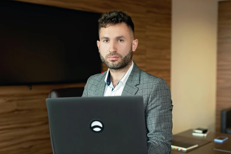 a man sitting in front of a laptop computer, by Adam Marczyński, hurufiyya, a man wearing a black jacket, avatar image, christian dimitrov, high quality image