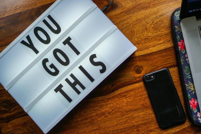 a laptop computer sitting on top of a wooden table, pexels contest winner, happening, bright signage, taken on an iphone, positive vibes, spotlight from above