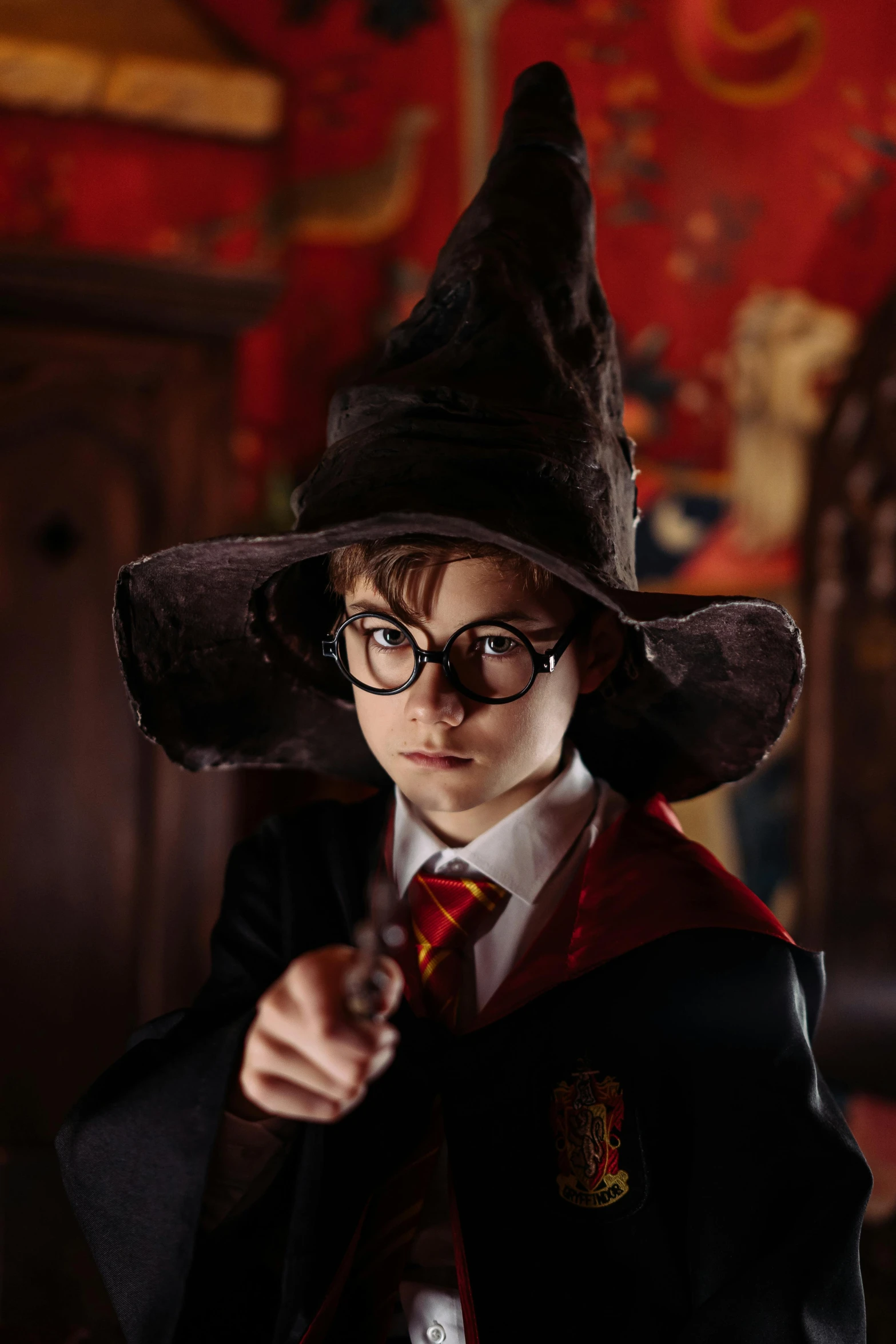 a young boy dressed in a harry potter costume, pexels, process art, pointy conical hat, with glasses on, gif, hogwarts gryffindor common room