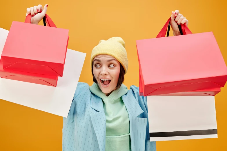 a woman holding two shopping bags over her head, trending on pexels, avatar image, maisie williams, scarlet and yellow scheme, professional image