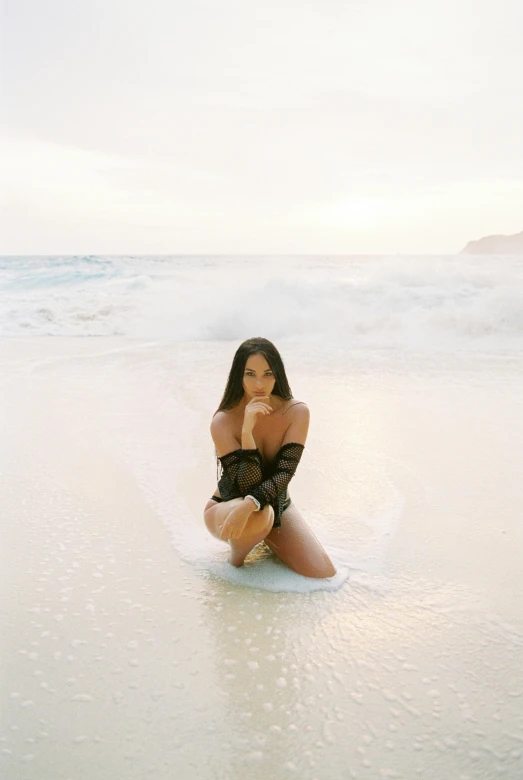 a woman sitting on top of a beach next to the ocean, demi rose, floating in the ocean, soft glow, shot on webcam