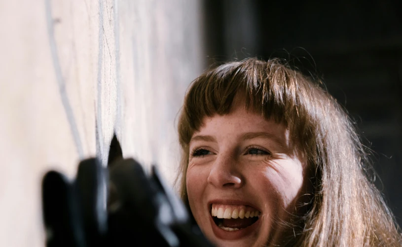 a close up of a person holding a pair of scissors, an album cover, inspired by Sheila Mullen, pexels contest winner, smiling laughing, female blacksmith, film still from horror movie, bangs