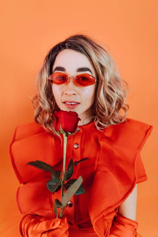 a woman in a red dress holding a rose, an album cover, trending on pexels, wearing orange sunglasses, pokimane, profile image, billy butcher