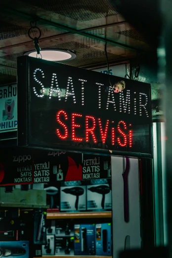 a sign that is on the side of a building, by Matija Jama, pexels contest winner, serial art, turkish and russian, at the counter, soft lighting, server in the middle