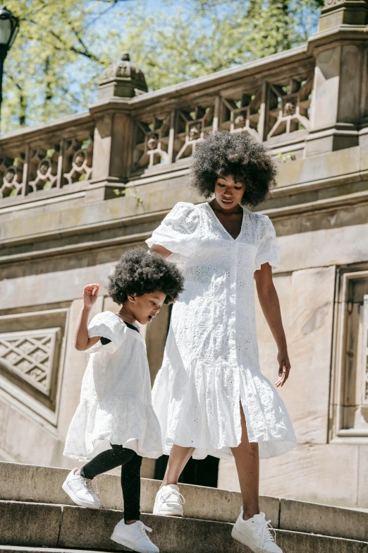 a woman and a child walking up a set of stairs, wearing a white folkdrakt dress, off - white collection, bedhead, white dress shirt