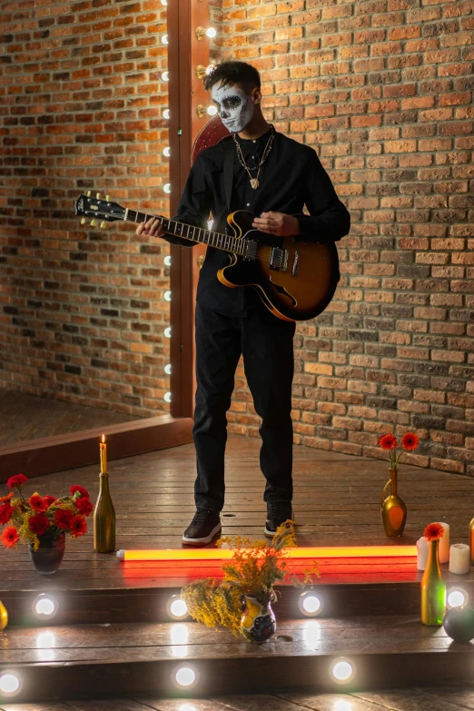 a man that is playing a guitar in a room, masked person in corner, standing in a restaurant, promo shoot, on the altar