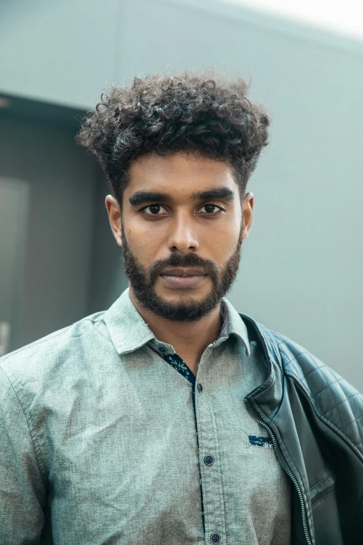 a close up of a person wearing a jacket, by Jacob Toorenvliet, sri lanka, curly middle part haircut, promo image, multiple stories