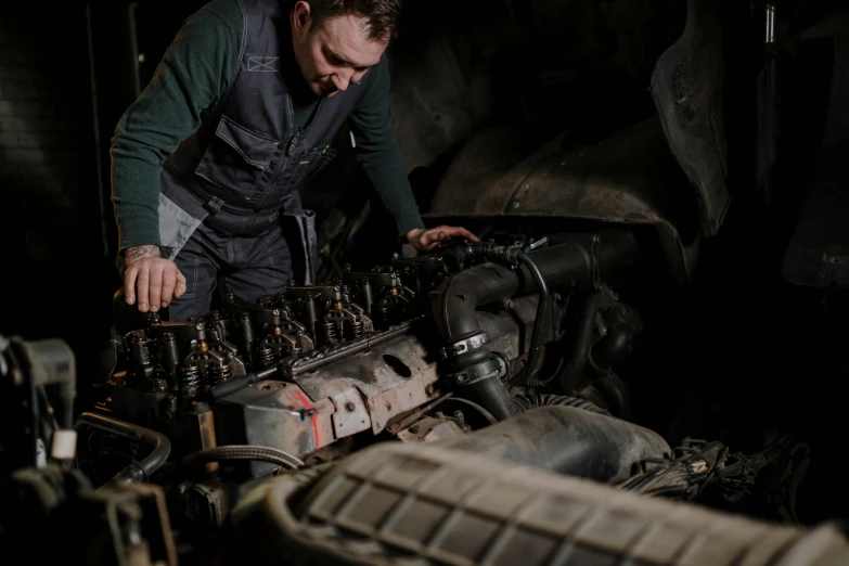 a man working on an engine in a garage, a portrait, pexels contest winner, renaissance, 15081959 21121991 01012000 4k, rugged and dirty, full colour, aftermarket parts