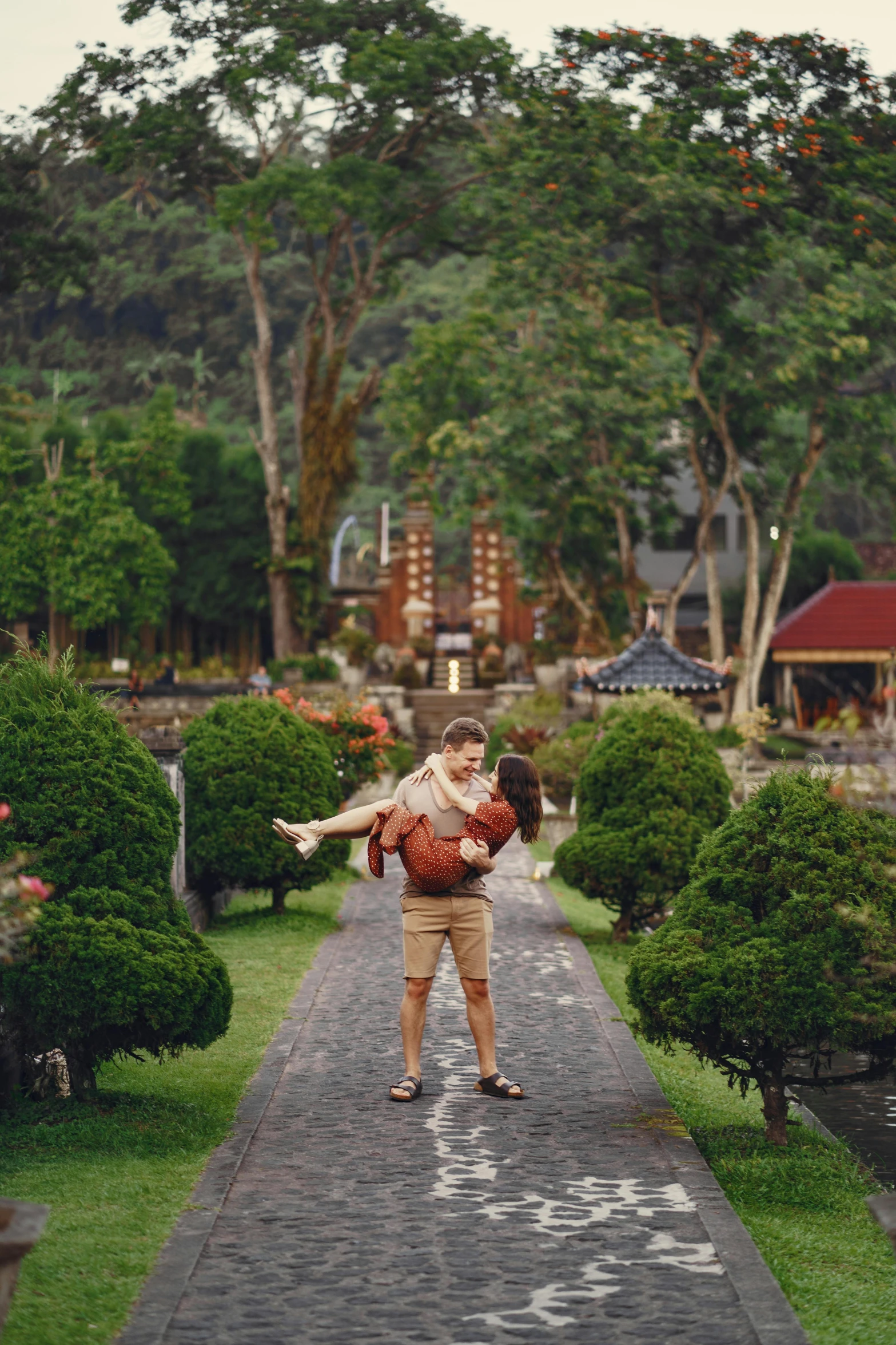 a man carrying a woman on his back in a park, a picture, pexels contest winner, sumatraism, vietnamese temple scene, avatar image, lush surroundings, instagram photo