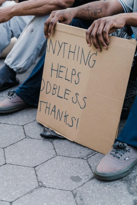a group of people sitting next to each other holding a sign, by Matija Jama, trending on unsplash, skilled homeless, shows a leg, thanks, thumbnail