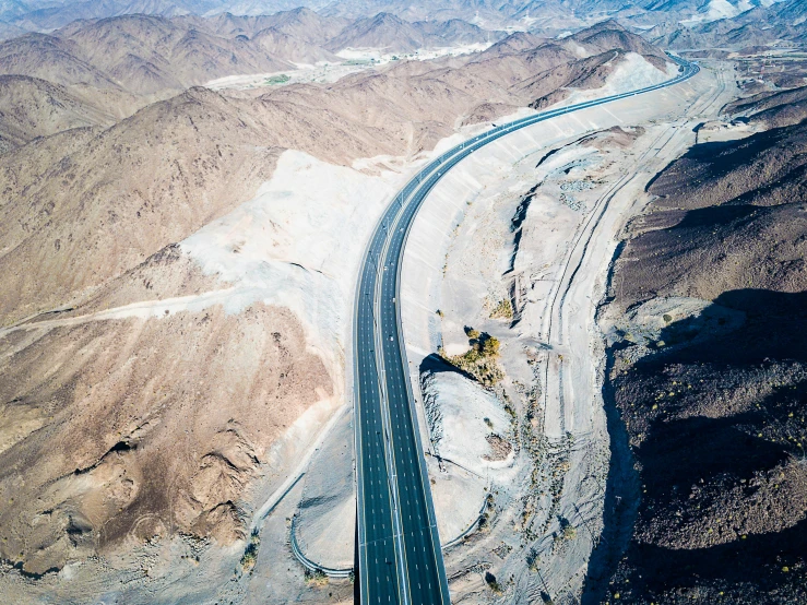 an aerial view of a road in the desert, under construction, liam brazier, destroyed mountains, lpoty