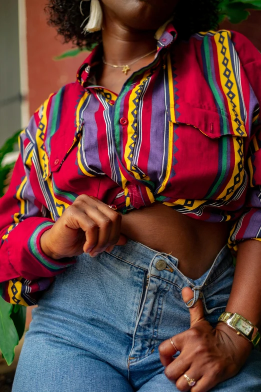 a woman in a colorful shirt and jeans posing for a picture, an album cover, by Lily Delissa Joseph, trending on pexels, renaissance, midriff, detail shot, on a canva, 1990
