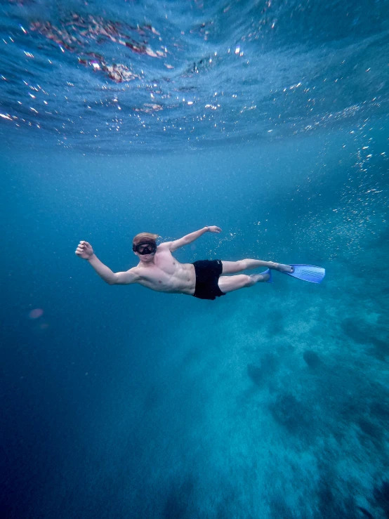 a man swimming in the ocean with a snorg, a screenshot, pexels contest winner, lachlan bailey, clear blue water, fins, floating headsets