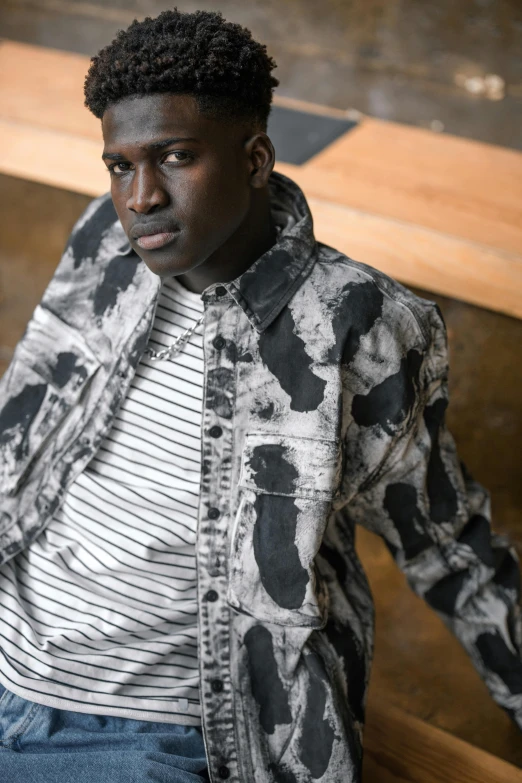 a man sitting on top of a wooden bench, an album cover, inspired by Theo Constanté, trending on pexels, photorealism, patterned clothing, black chalk, portrait featured on unsplash, denim