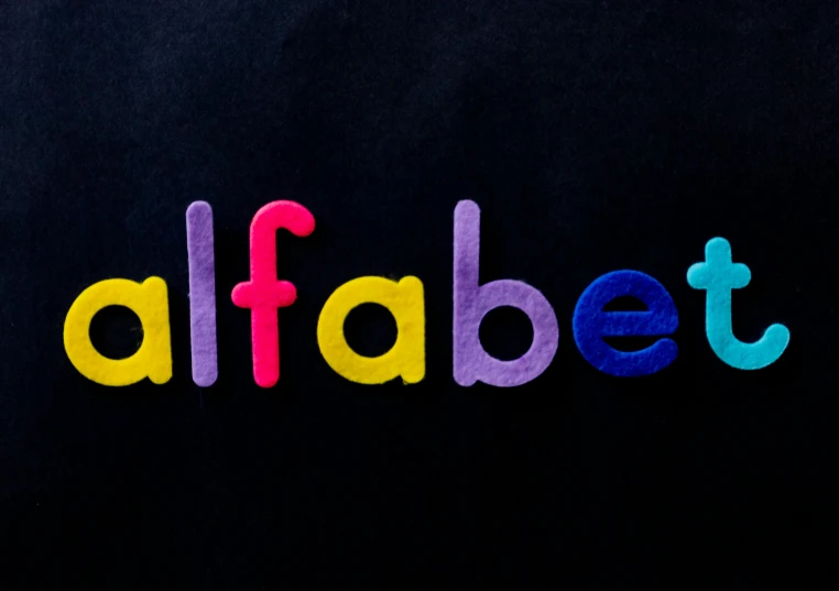 a close up of the word alphabet on a black background, by Isabel Naftel, pixabay, felting, vibrant tones, lalafell, taliban