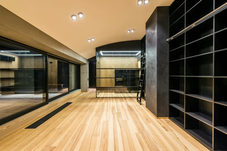 a wooden floor in a room with bookshelves, by Adam Marczyński, light and space, gold and black color scheme, archdaily, rapper, “ iron bark