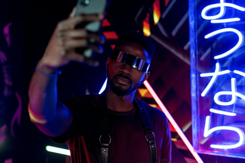 a man taking a selfie in front of a neon sign, a hologram, pexels, afrofuturism, reflecting light in a nightclub, futuristic glasses lenses, black mirror series, portrait of tall