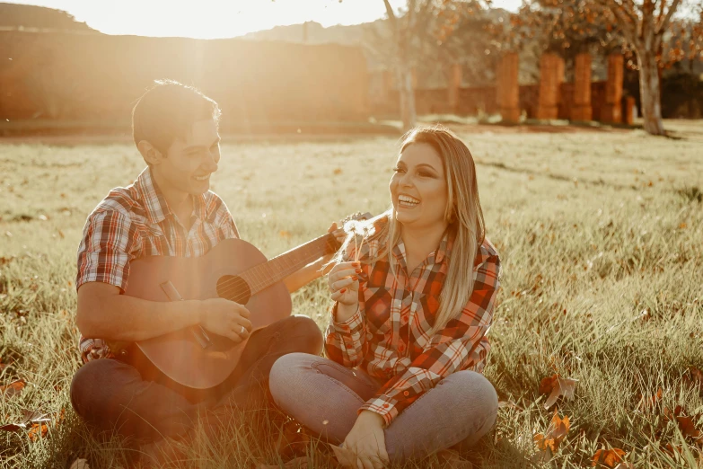 a man and a woman sitting in a field playing guitar, a picture, by Matt Cavotta, pexels contest winner, flannel, avatar image, younger brother vibes, on a farm