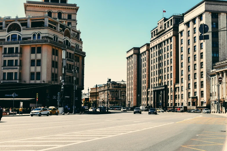 a city street filled with lots of tall buildings, pexels contest winner, socialist realism, russian neoclassicism, intersection, palace, warm spring