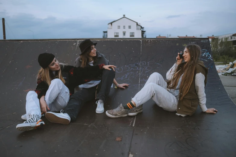 a group of young women sitting on top of a skateboard ramp, by Emma Andijewska, trending on pexels, girl sitting on a rooftop, three women, profile image, cracks