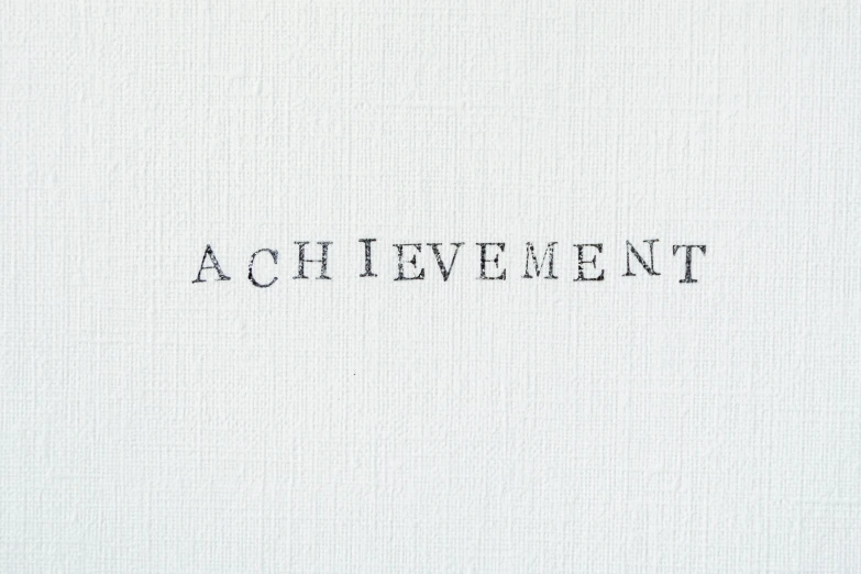 a piece of paper with the words achievement written on it, an album cover, by Celia Fiennes, aestheticism, synthetic polymer paint on linen, simple white background, abundent in details, 1.2