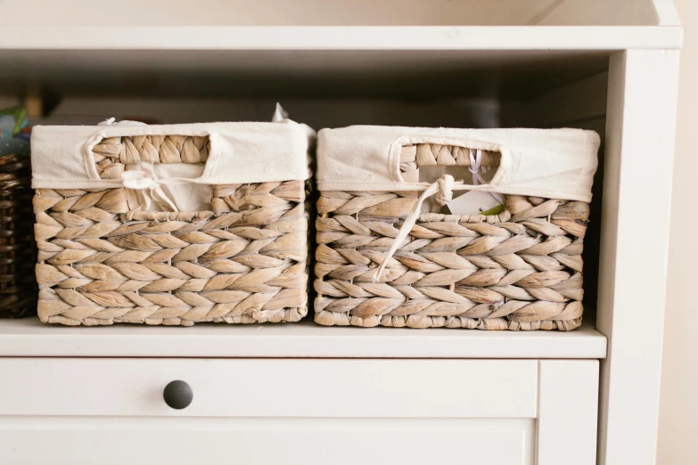 two baskets sitting on top of a white cabinet, unsplash, rectangle, item, middle close up, linen